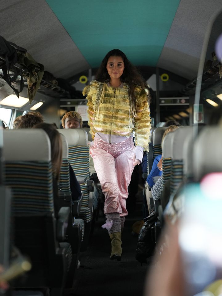 Le 1er décembre 2025, un mannequin présente une création à bord d'un TGV, dans le cadre de la semaine de la mode circulaire, sur le trajet Paris-Lille. (CIRCULAR FASHION)