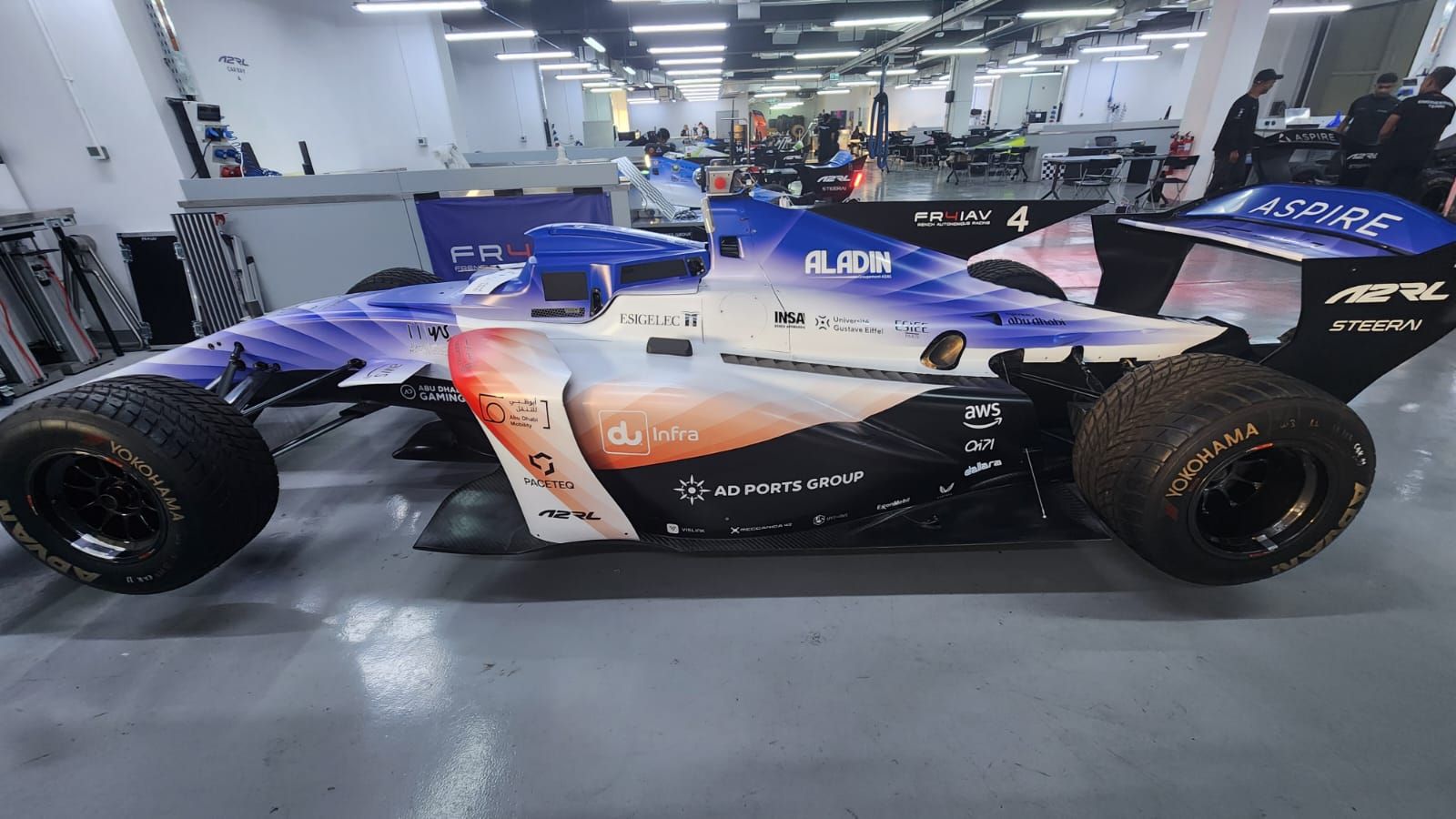 étudiants et ingénieurs engagés dans une course de voitures autonomes