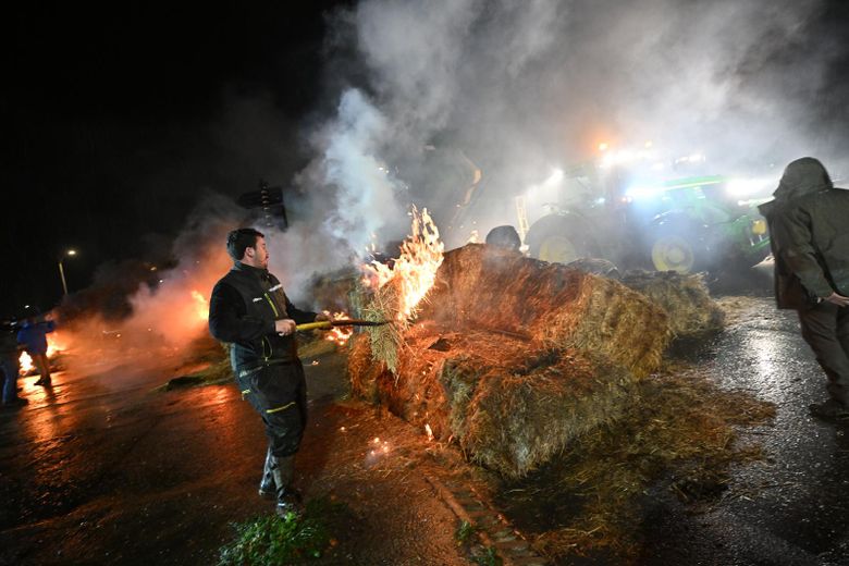 Un agriculteur mettant le feu à du foin.