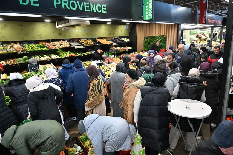 Beaucoup de monde se pressant pour acheter des fruits et des légumes.