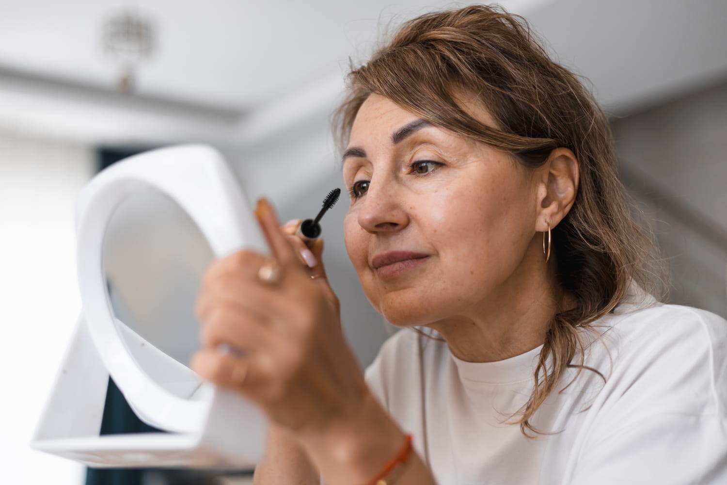 Après 50 ans, les maquilleurs pros recommandent ce geste qui ouvre le regard instantanément