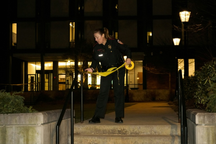 Une policière de l'université Brown délimite le périmètre autour du bâtiment Barus & Holley où ont eu lieu des tirs, le 13 décembre 2025, à Providence (Rhode Island) ( AFP / Bing Guan )