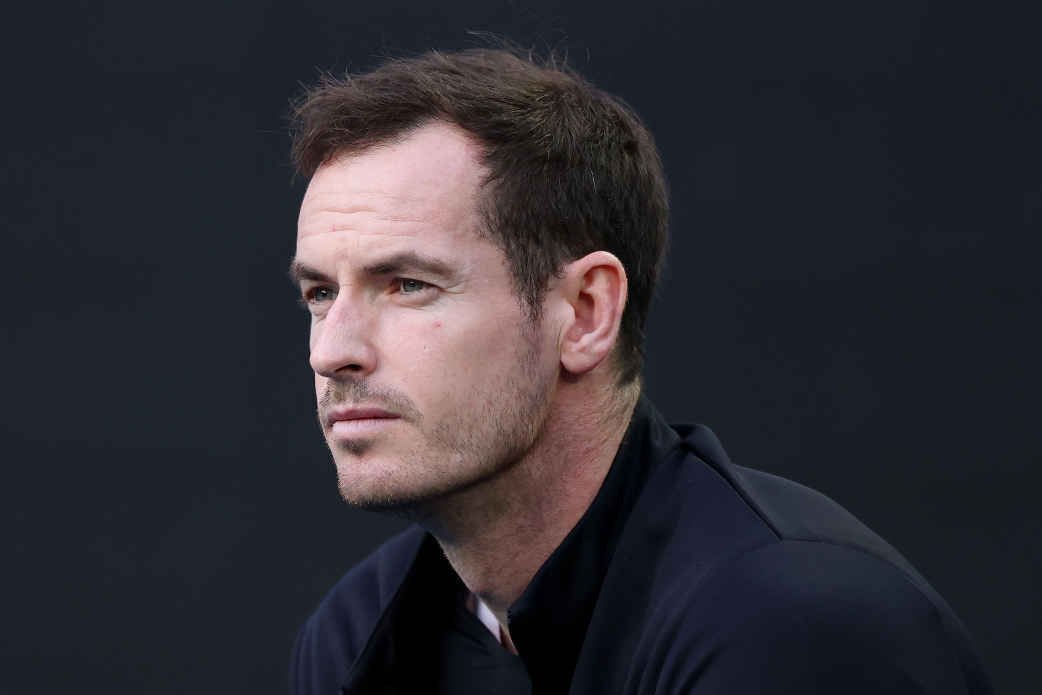 Andy Murray, assis en tant qu’entraîneur de Novak Djokovic, observe un match de tennis à l’Open d’Australie 2025.