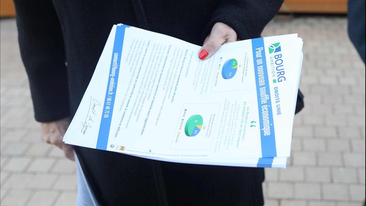 Le tract distribué par l'équipe de Bourg Ambition, menée par Benoît de Boysson, sur le marché de Noël de Bourg-en-Bresse, le 12 décembre 2025. (LAURE COMETTI / FRANCEINFO)