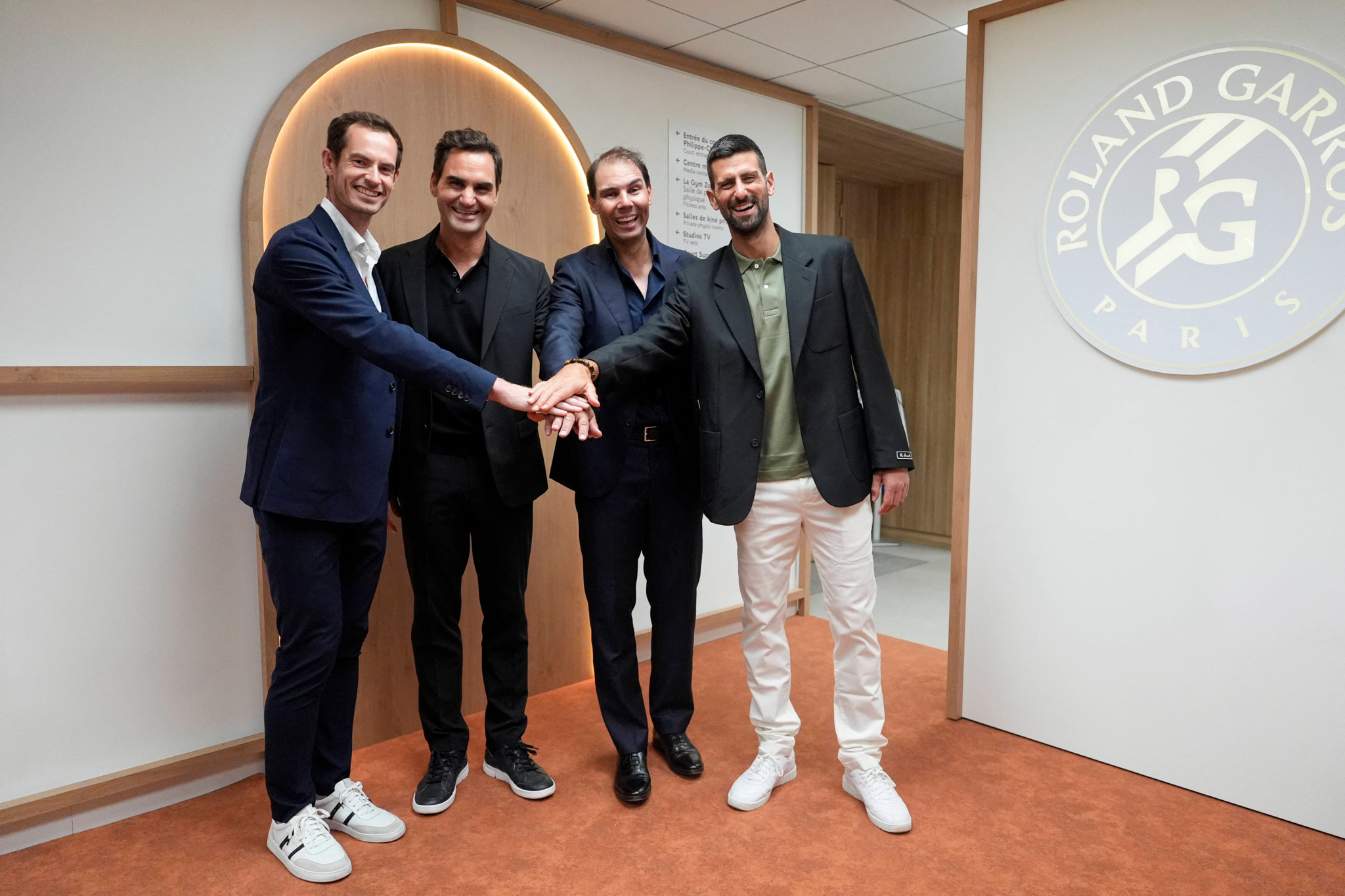 Andy Murray, Roger Federer, Rafael Nadal et Novak Djokovic se tenant les mains en hommage à Rafael Nadal lors du tournoi de Roland Garros 2025 à Paris.
