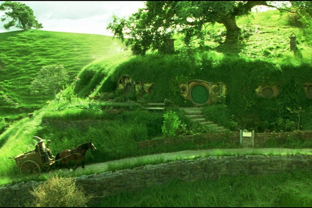 Photo extrait du film Le Seigneur des Anneaux montrant des maisonsdans des collines recouvertes d'herbe