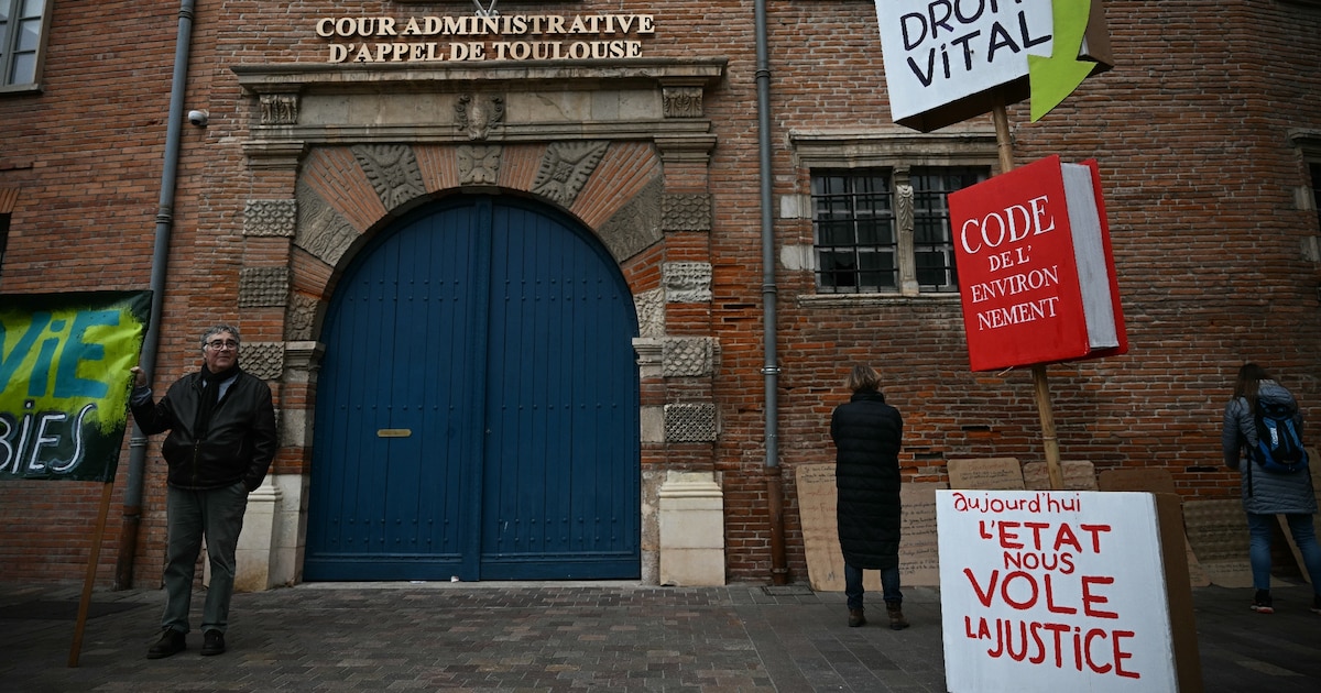 Un homme brandit une pancarte lors d’une manifestation contre le projet d’autoroute A69, devant la cour administrative d’appel à Toulouse, le 11 décembre 2025