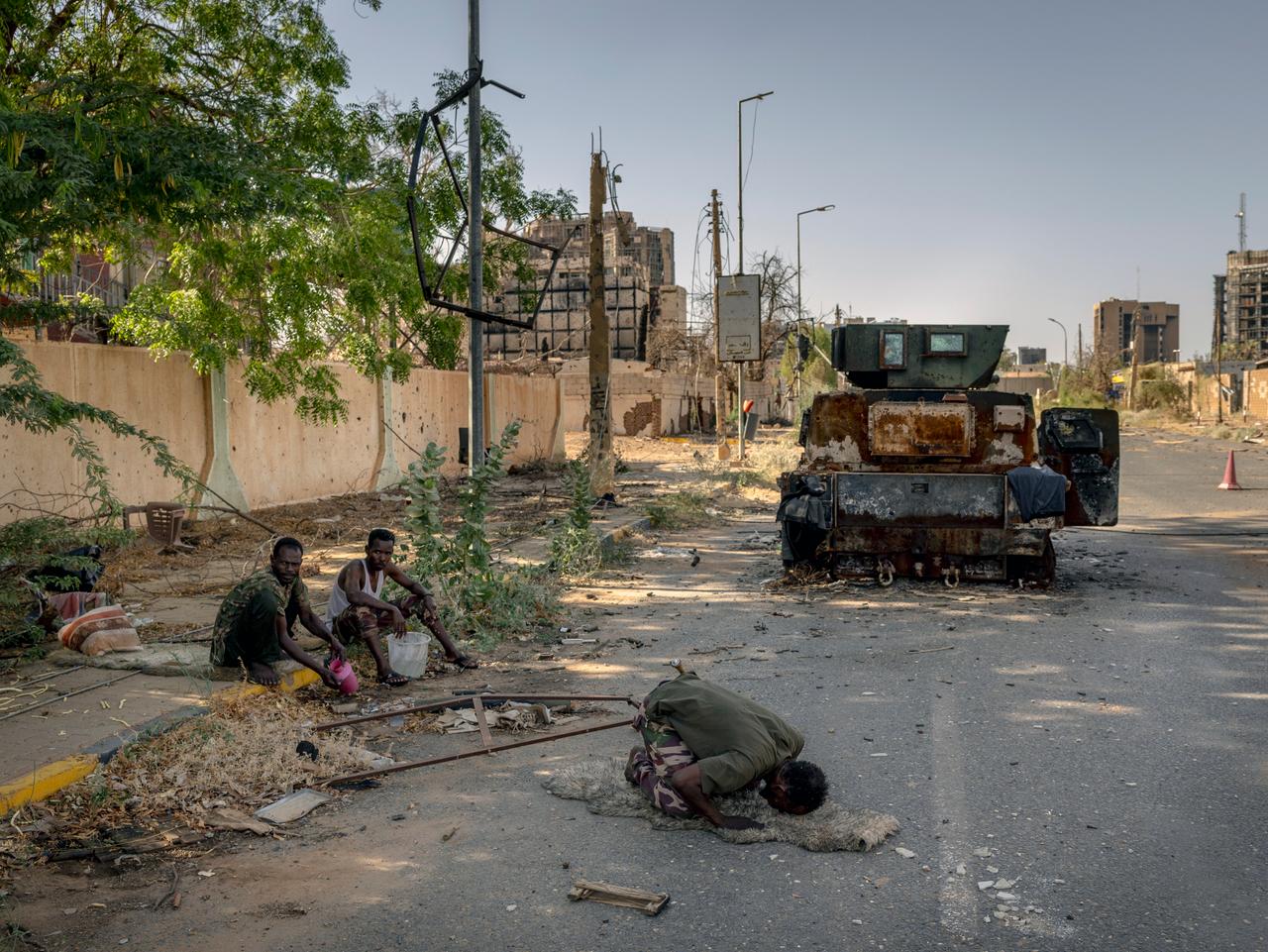 DANS L’ENFER DU SOUDAN. À Khartoum, le 28 mars 2025, un soldat soudanais prie devant un véhicule blindé incendié. Cette guerre qui échappe aux radars de l’actualité et qui oppose, depuis avril 2023, les paramilitaires des Forces de soutien rapide (FSR) du général Mohamed Hamdane Daglo, dit “Hemeti”, aux forces armées soudanaises (FAS), dirigées par le général Abdel Fattah Al-Burhan, provoque “la pire crise humanitaire et de déplacement au monde”, selon l’ONU. Près de 13 millions de personnes ont été déplacées, les maladies (choléra, dengue, paludisme) se propagent et la famine, confirmée dans dix régions, s’étend.