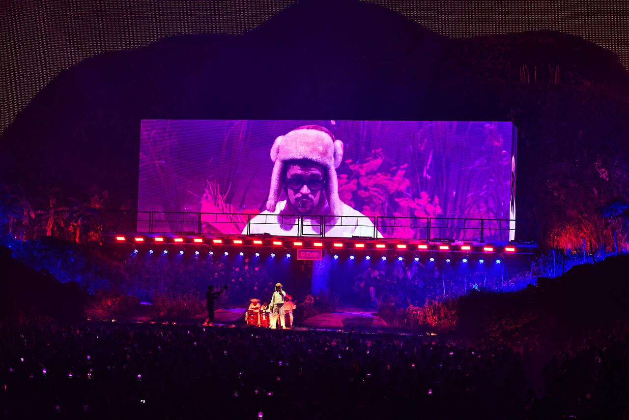 LA VOIX DE PORTO RICO. Au Coliseo de San Juan, le 9 août 2025. Pendant trois mois, Bad Bunny électrise les foules dans son île natale, où il a choisi de lancer sa tournée mondiale (qui évite par ailleurs les États-Unis) par une série de trente concerts. Du jamais-vu. Un événement par ses répercussions sur l’économie portoricaine mais aussi par sa dimension politique : avec cette résidence musicale – baptisée “No me quiero ir de aquí” (“Je ne veux pas partir d’ici”) – conçue pour célébrer la culture et l’identité portoricaine, Bad Bunny nourrit le feu indépendantiste, estime la presse étrangère. 