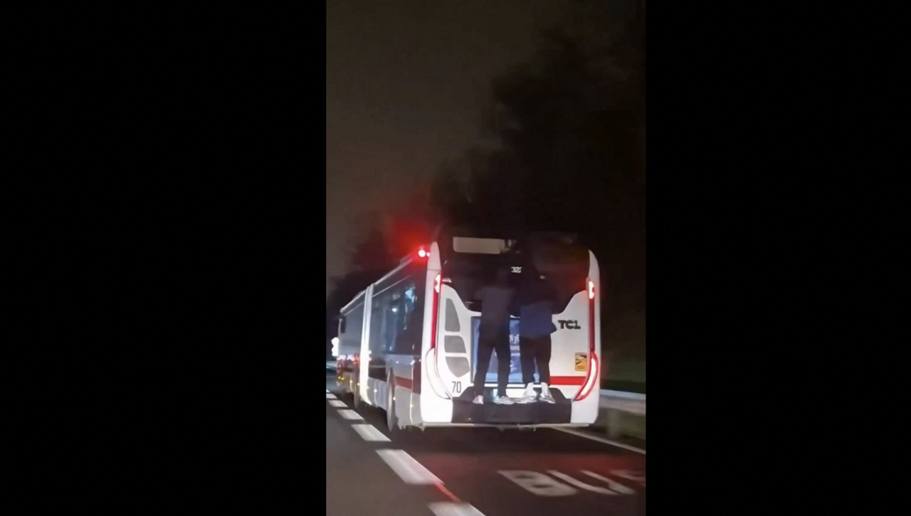 deux personnes filmées accrochés à un bus TCL circulant sur la M6