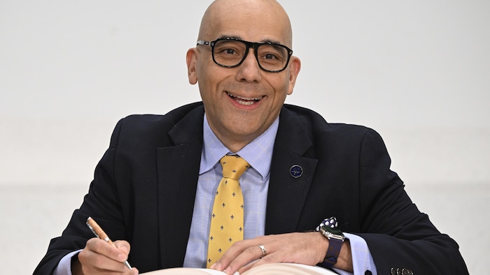 Christopher Skeete signe un document.