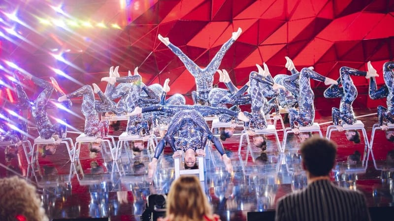 La pratique, sportive et artistique, est une chorégraphie inversée avec un appui sur un tabouret de yoga.