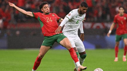 Le milieu marocain Neil El Aynaoui (à gauche) au duel avec son homologue des Comores Iyad Mohamed à l'occasion du match d'ouverture de la CAN, le 21 décembre 2025. (SEBASTIEN BOZON / AFP)