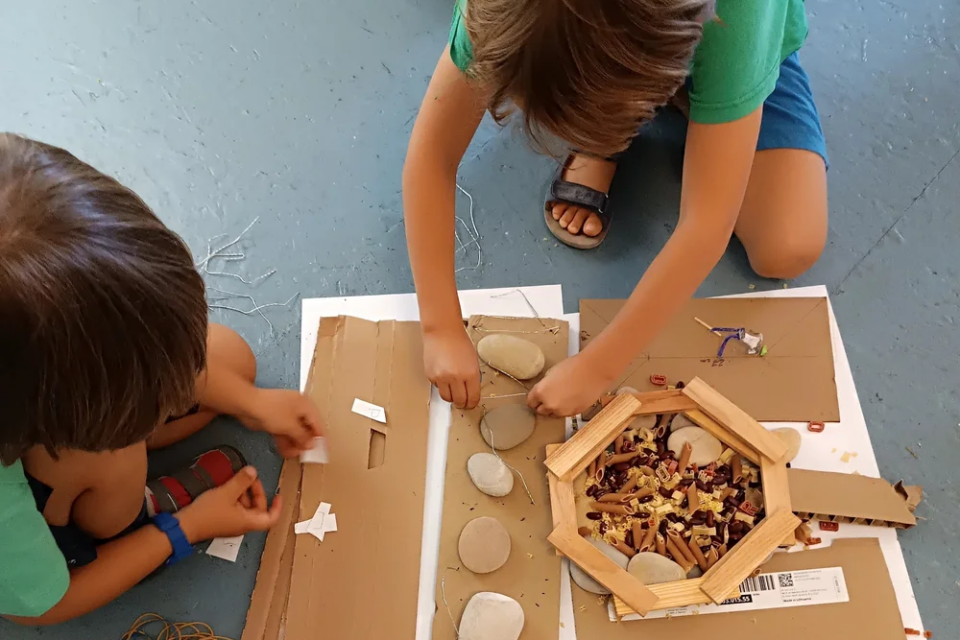 Les enfants manipulent des planchettes pour imaginer des architectures éphémères.