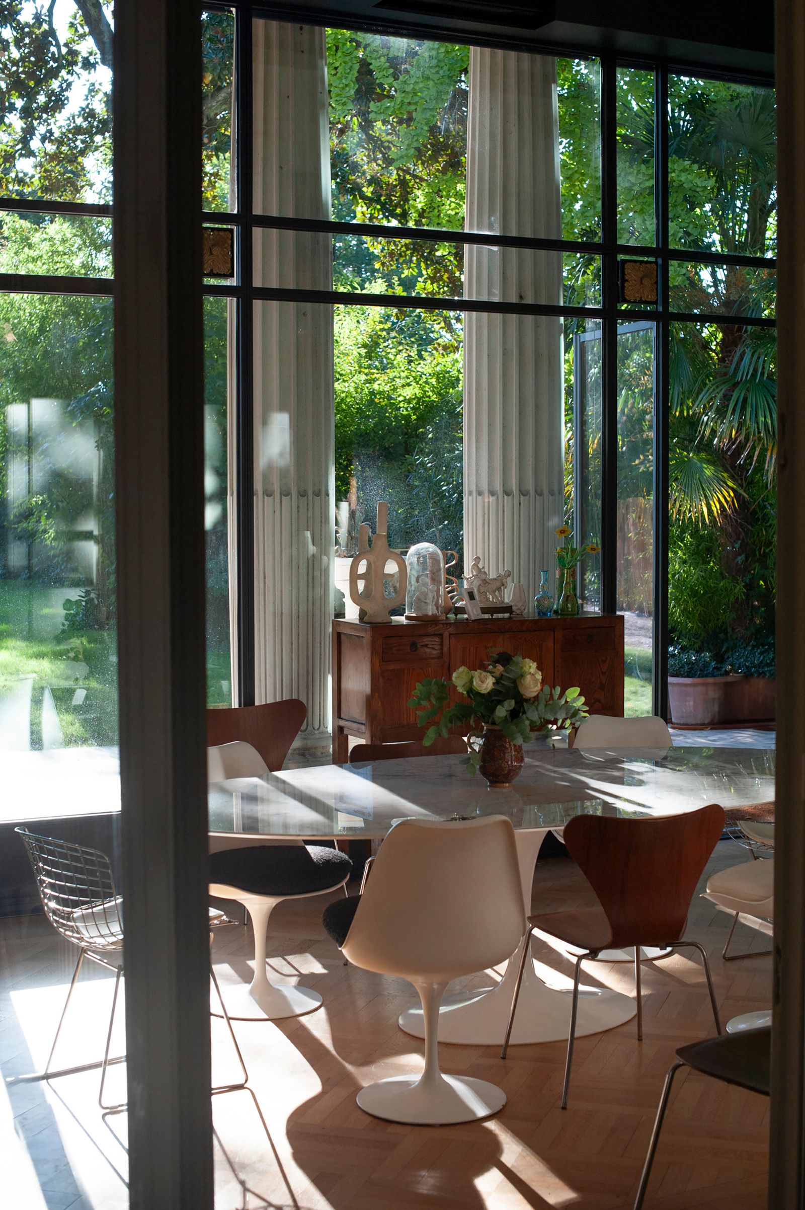 Le mobilier contemporain s'intègre de façon naturelle au bâti  la table Tulipe de Knoll est entoure de chaises Srie 7...