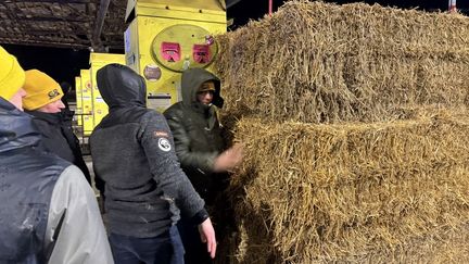 Des agriculteurs installent des bottes de paille pour bloquer une autoroute dans le Nord de la France, le 11 janvier 2026. (BENJAMIN BOULY RAMES / AFP)