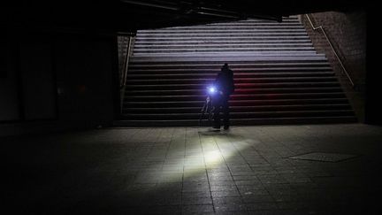 Un homme circule à vélo dans la gare de Wannsee après une coupure de courant à Berlin, en Allemagne, le 3 janvier 2026. (MICHAEL KAPPELER / DPA / AFP)