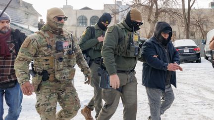 Des agents des douanes et de la protection des frontières arrêtent un homme lors d'une opération de contrôle de l'immigration à Minneapolis, dans le Minnesota, aux Etats-Unis, le 11 janvier 2026. (MADISON THORN / ANADOLU / AFP)