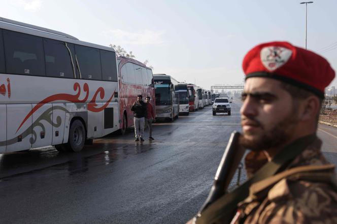 Des bus attendent pour entrer dans le quartier de Cheikh-Maqsoud afin d’évacuer les combattants des Forces démocratiques syriennes, dirigées par les Kurdes, de deux quartiers de la ville d’Alep, dans le nord de la Syrie, le 9 janvier 2026.
