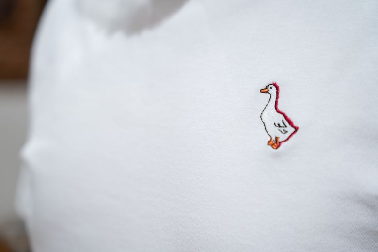 L’oie délicatement brodée sur la poitrine