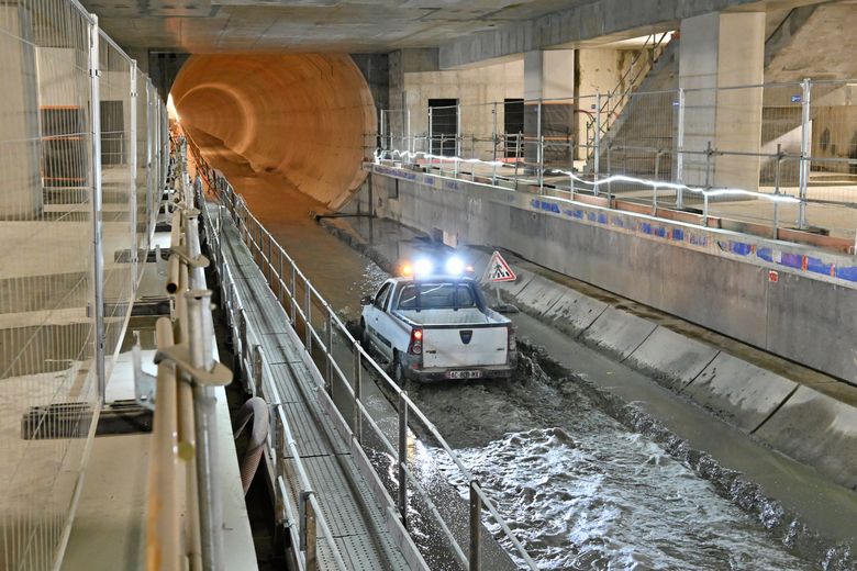 La future station, et des ouvriers qui travaillent au terrassement du tunnel.
