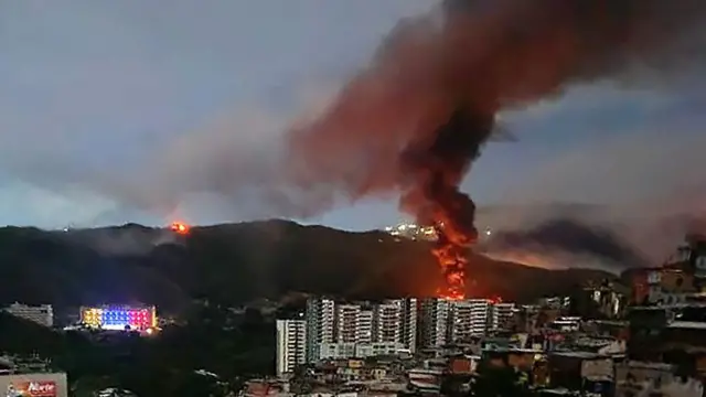 Incendie à Fuerte Tiuna, le plus grand complexe militaire du Venezuela, vu de loin après une série d'explosions à Caracas. 