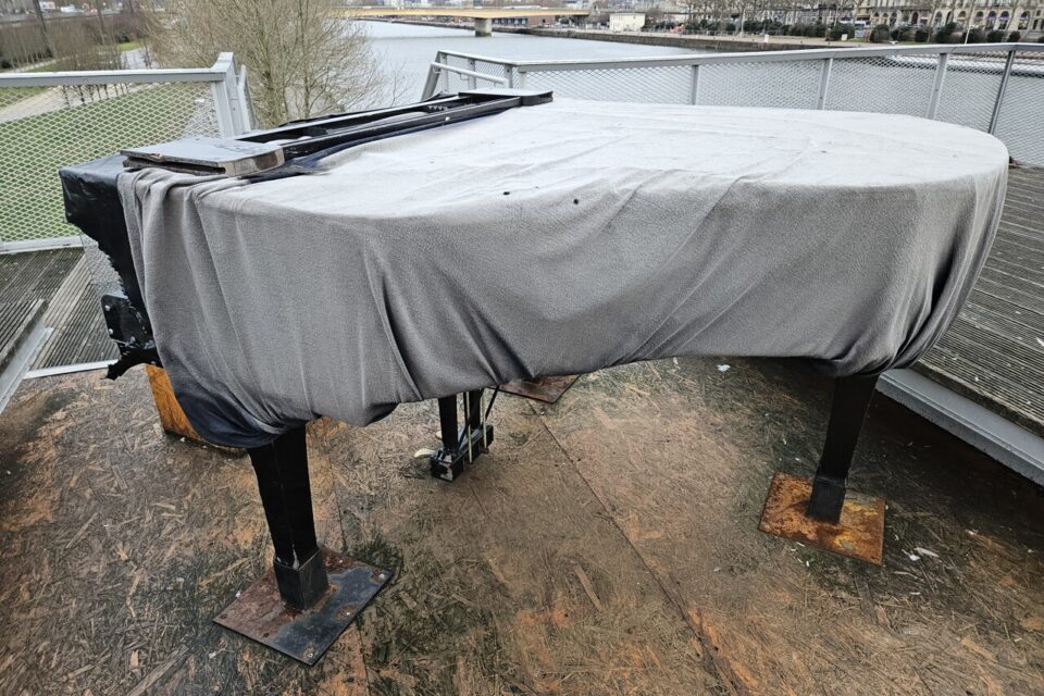 Le corps du piano est bâché, le clavier est à nu.