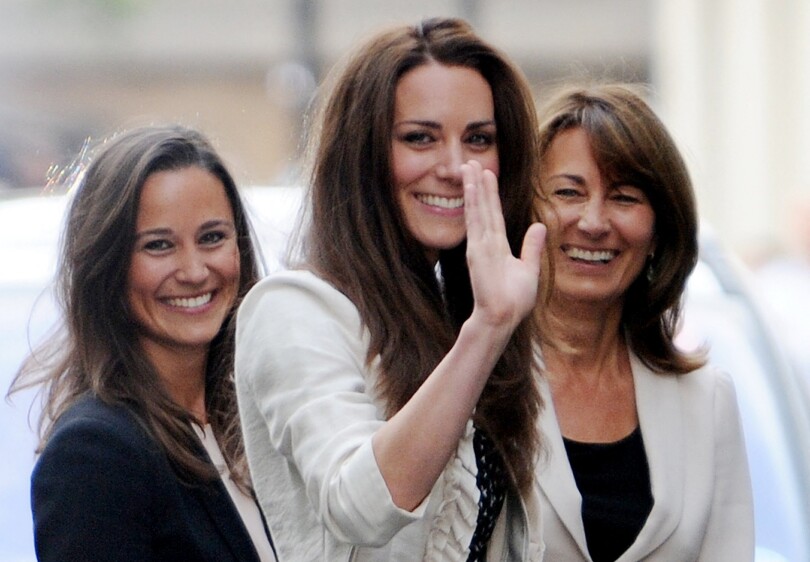 La jeune Kate Middleton salue la foule devant le Goring Hotel, à Londres, alors qu'elle passe sa dernière journée de célibataire avec sa mère Carole et sa sœur Pippa, à la veille de son mariage avec le prince William, le 28 avril 2011.