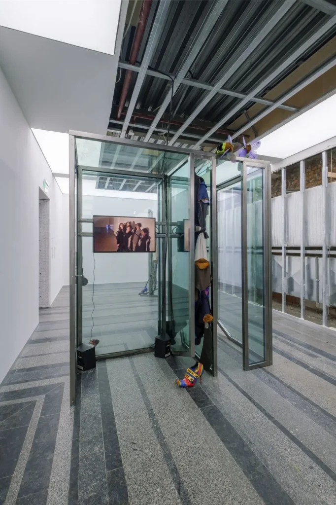 Agata Ingarden - Rescue Dummies: In-corporate Elevators and Friends wearing Suits, 2021. Fenêtres trouvées dans un immeuble de bureaux (69 Kyrylivska, Kiev), vidéo multicanal, son, sculptures en bois, sculptures en bronze, costumes en stores de bureau, vêtements faits main, chaussures, harnais, lumières, cire, cuivre, ruban adhésif. Installation pour le Future Generation Art Prize 2021, prix spécial, Pinchuk Art Center, Kiev, 2021.