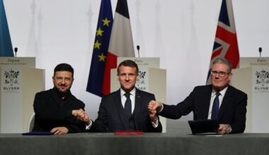 Le président ukrainien Volodymyr Zelensky, le président français Emmanuel Macron et le Premier ministre britannique Keir Starmer se serrent la main à l'occasion de la signature de la déclaration sur le déploiement de forces en Ukraine après le cessez-le-feu, lors du sommet dit de la "Coalition des volontaires", au palais de l'Élysée à Paris, le 6 janvier 2026.