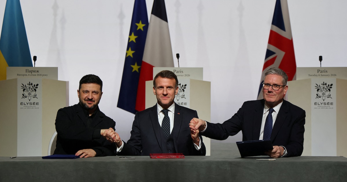 Le président ukrainien Volodymyr Zelensky, le président français Emmanuel Macron et le Premier ministre britannique Keir Starmer se serrent la main à l'occasion de la signature de la déclaration sur le déploiement de forces en Ukraine après le cessez-le-feu, lors du sommet dit de la "Coalition des volontaires", au palais de l'Élysée à Paris, le 6 janvier 2026.
