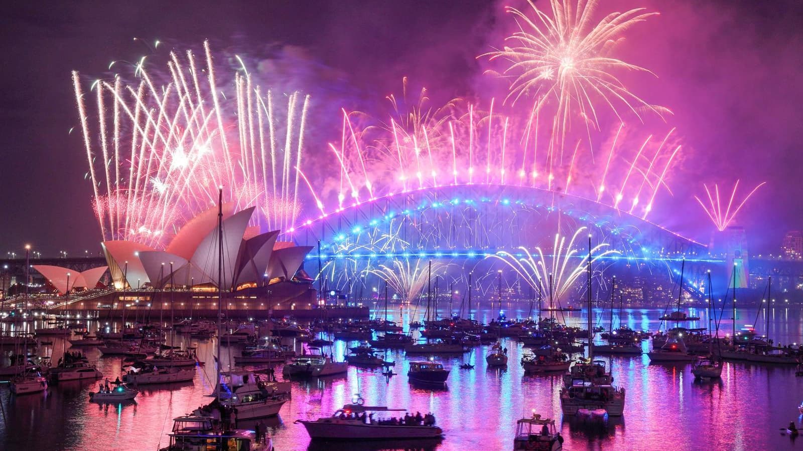 Des feux d'artifice illuminent le ciel au-dessus du pont du port de Sydney et de l'opéra lors des célébrations du Nouvel an, le 1er janvier 2026 à Sydney, en Australie.