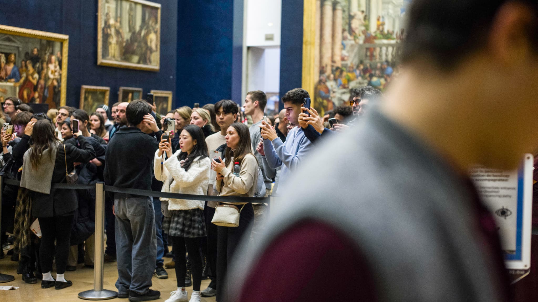 A Paris, au musée du Louvre, le 8 décembre 2025, des visiteurs venus admirer la Joconde et se prendre en photo devant elle. 