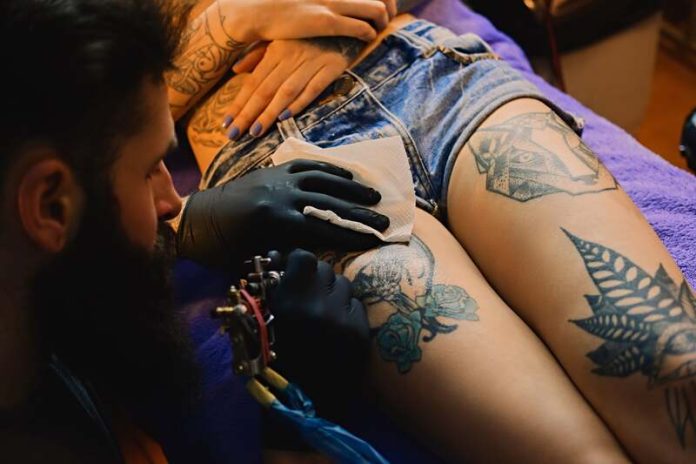 Les tatouages ont ils un impact sur notre santé altération système immunitare Ma Santé Une femme qui se fait tatouer sans savoir que l'encre peut avoir un impact sur son système immunitaire à long terme.