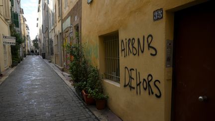 Un graffiti sur lequel on peut lire "Airbnb dehors" dans le quartier du Panier à Marseille, le 10 novembre 2023. (NICOLAS TUCAT / AFP)