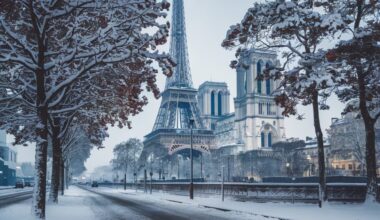 Rue de Paris enneigée avec des monuments emblématiques en arrière-plan.