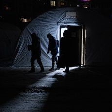 Des Ukrainiens quittent un point de ravitaillement, conçu pour faire face aux coupures d'électricité qui touchent le pays après des frappes russes ciblées, le 17 janvier 2026.