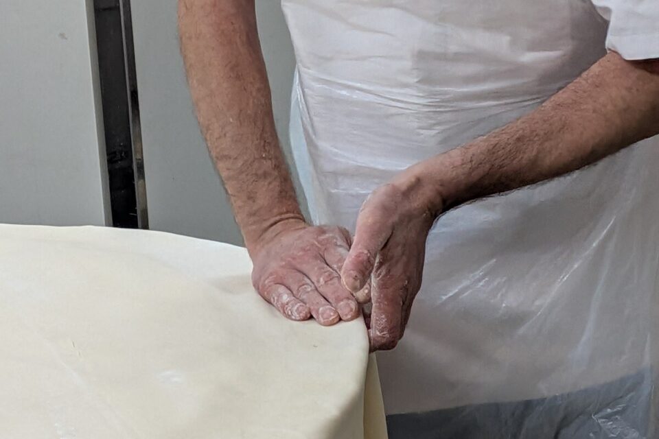 La découpe de la pâte pour obtenir des bords propres et nets.