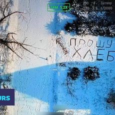 Une civile ukrainienne demande de l'aide par un message inscrit dans la neige. On peut lire "je demande du pain".