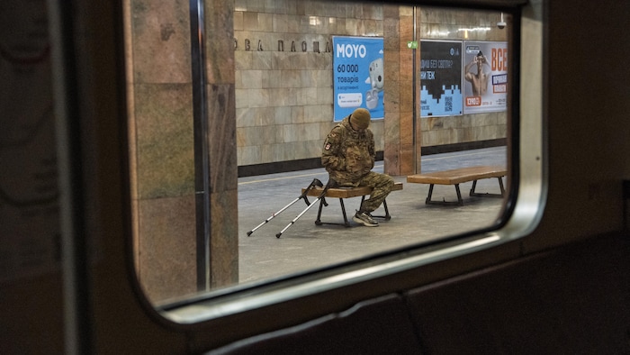 Un militaire amputé est assis sur un banc dans le métro de Kiev.