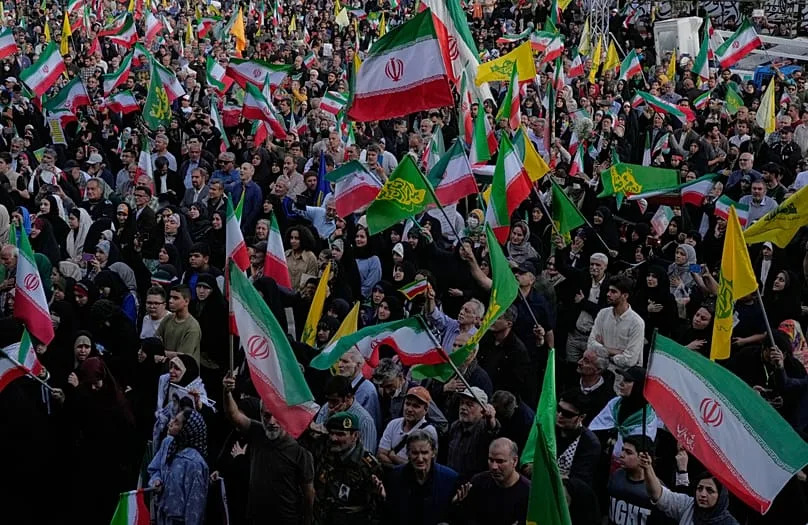 Des personnes agitent des drapeaux iraniens lors d'un rassemblement organisé par l'État à Téhéran, le 29 avril 2026.