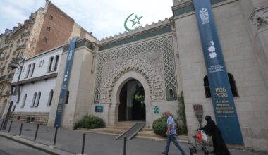 People walked past the Grand Mosque of Paris, where a banner reads, "100 years of light, a century of history, spirituality and dialogue" marking its 100th anniversary, on Friday.
