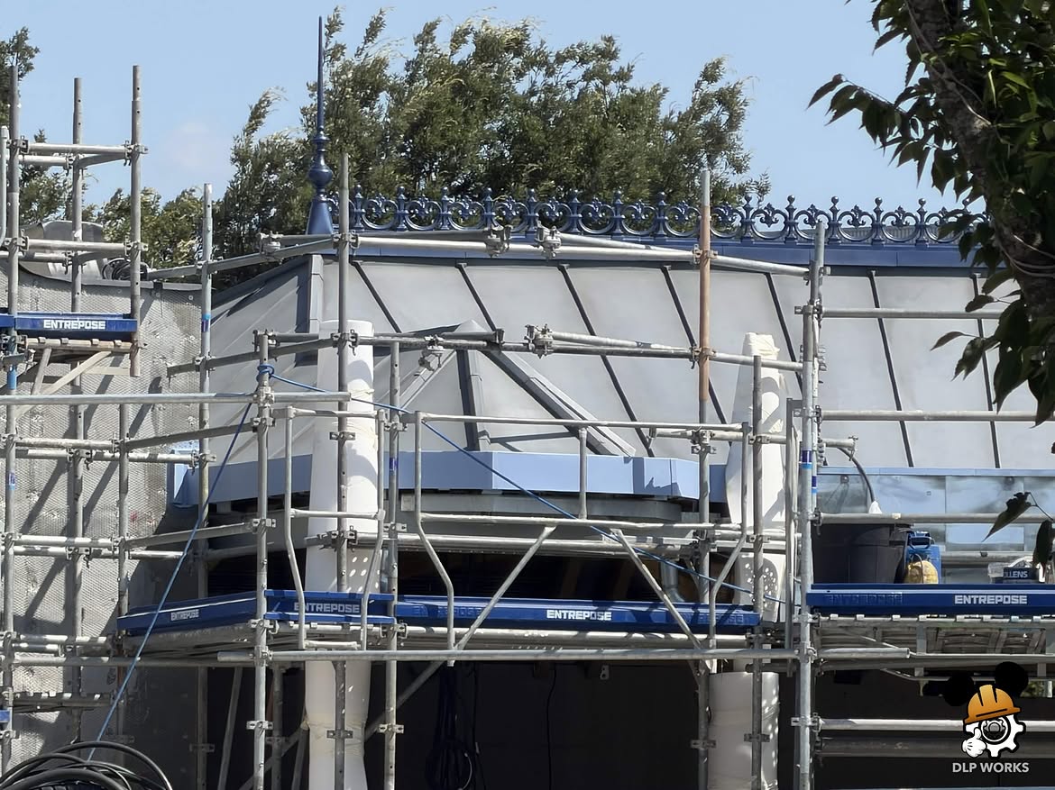Themed architectural elements are being added to the building for the ride's technical facilities. There are now columns, archways, and overhangs. Wooden frames act as molds while concrete hardens.