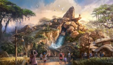 Visitors in Disneyland Paris marvel at a concept art-inspired rocky mountain ride with a cascading waterfall. Birds soar above while trees envelop the vibrant scene, buzzing with guests snapping photos and strolling through this enchanting oasis.