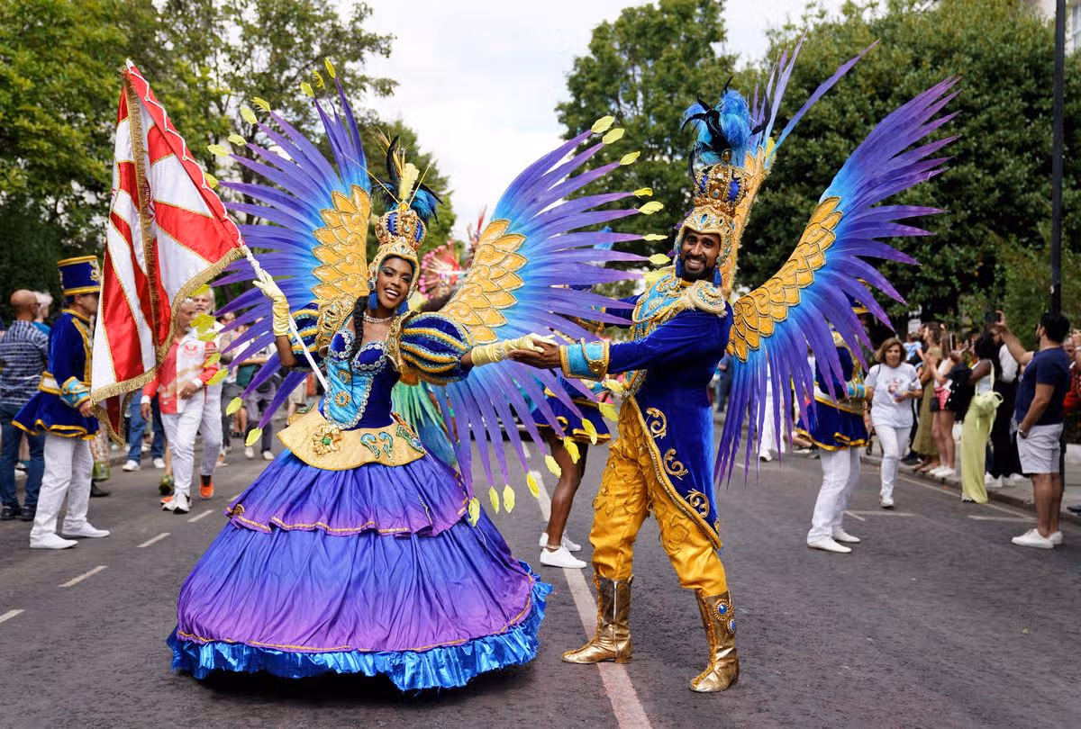 performers dazzled in bright costumes, with dramatic headpieces, as they entertained the dancing crowds who lined the parade route.