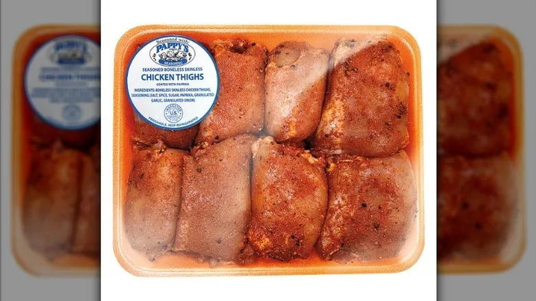Seasoned chicken thighs on white background