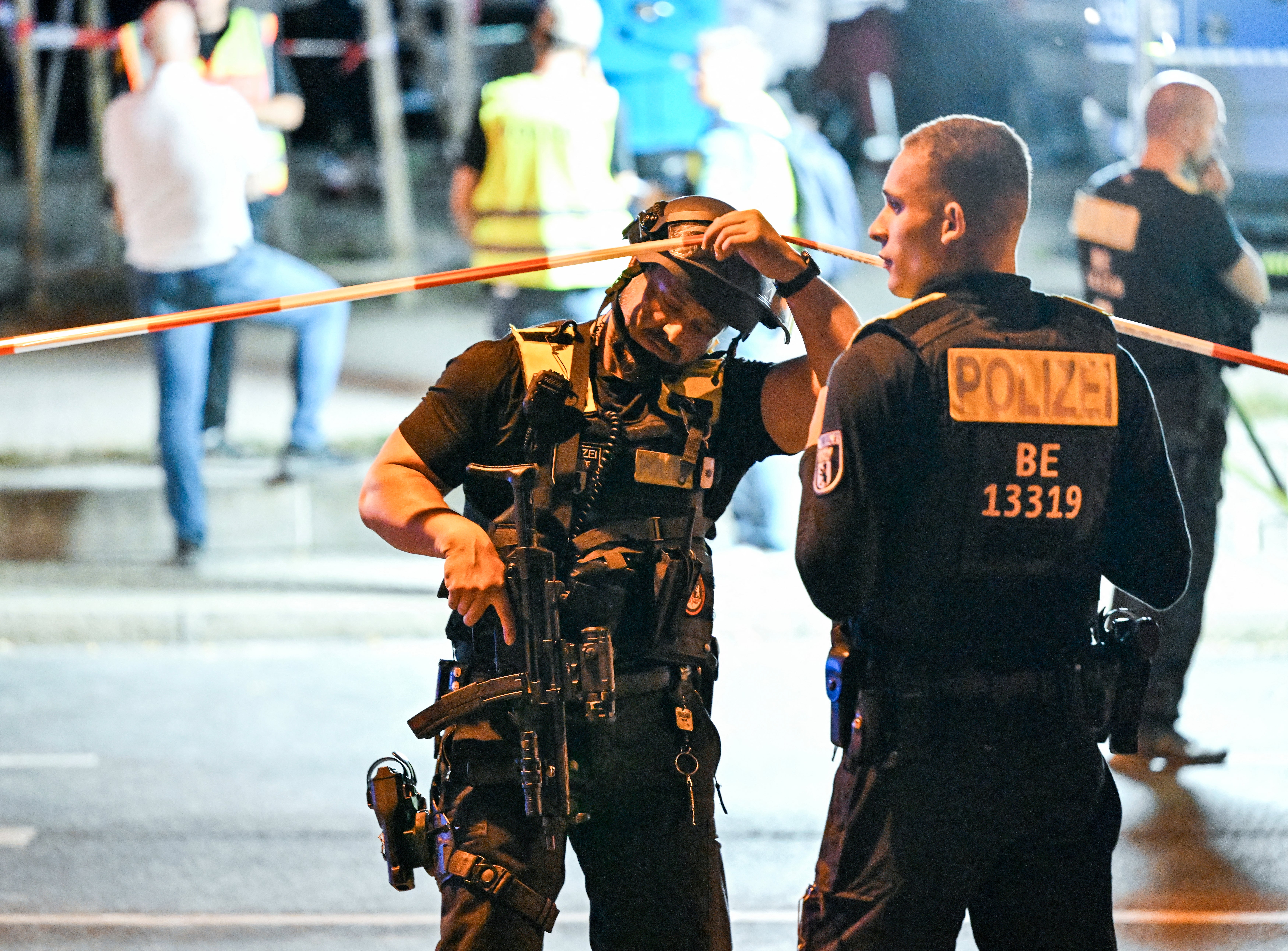 Armed police stand near the scene where one person was killed and around 16 injured after a car struck people on the outskirts of the Christopher Street Day (CSD) parade in Berlin, on July 25, 2026