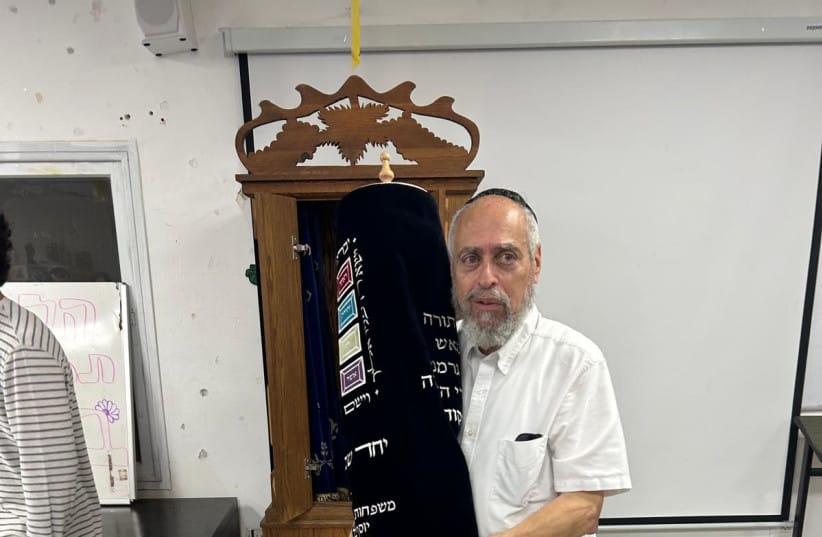Rabbi Aaron Adler holds the Torah scroll at the Sefer Torah dedication.