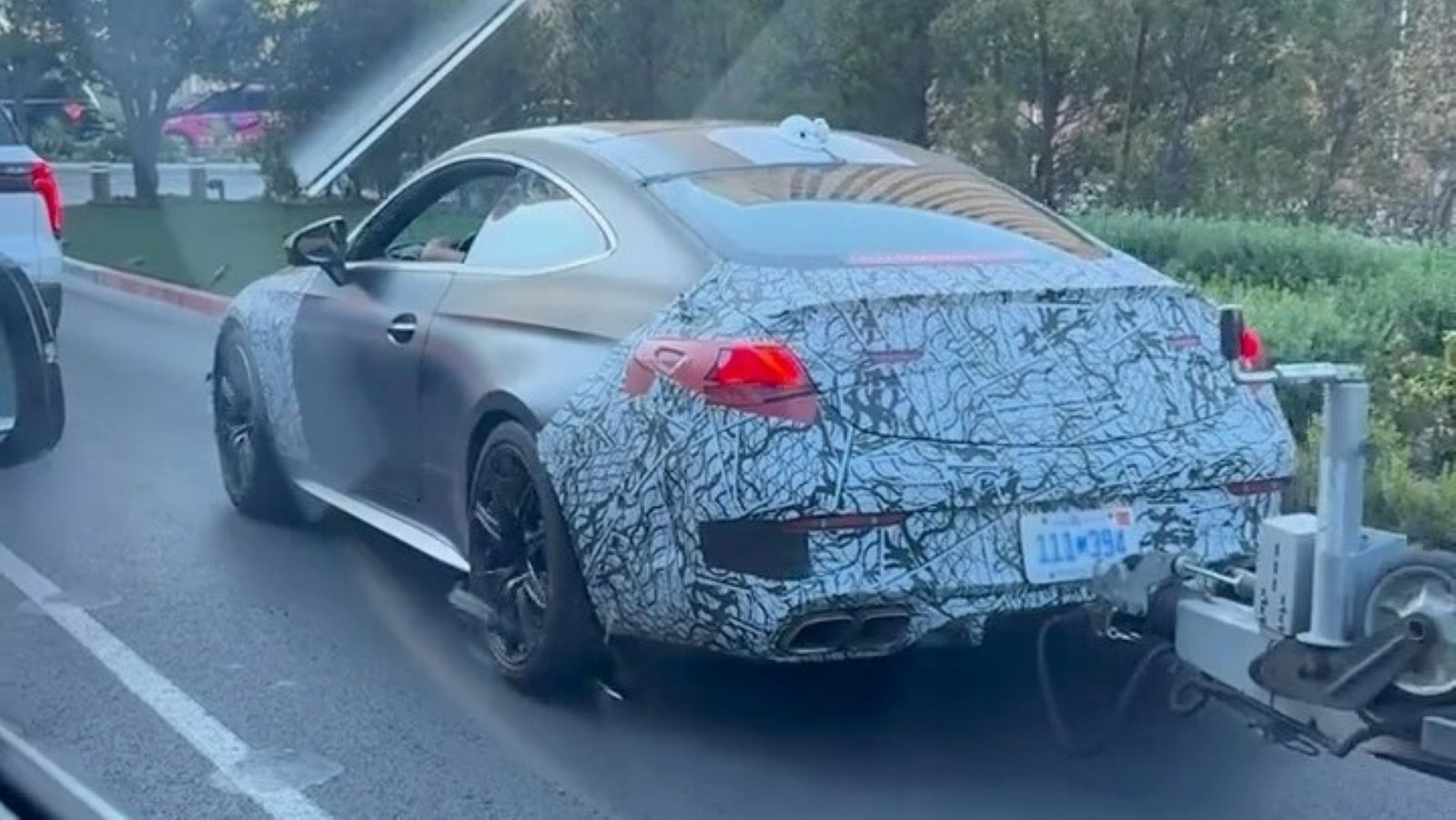 2027 Mercedes-AMG CLE 63 spied up close in traffic with an attached trailer