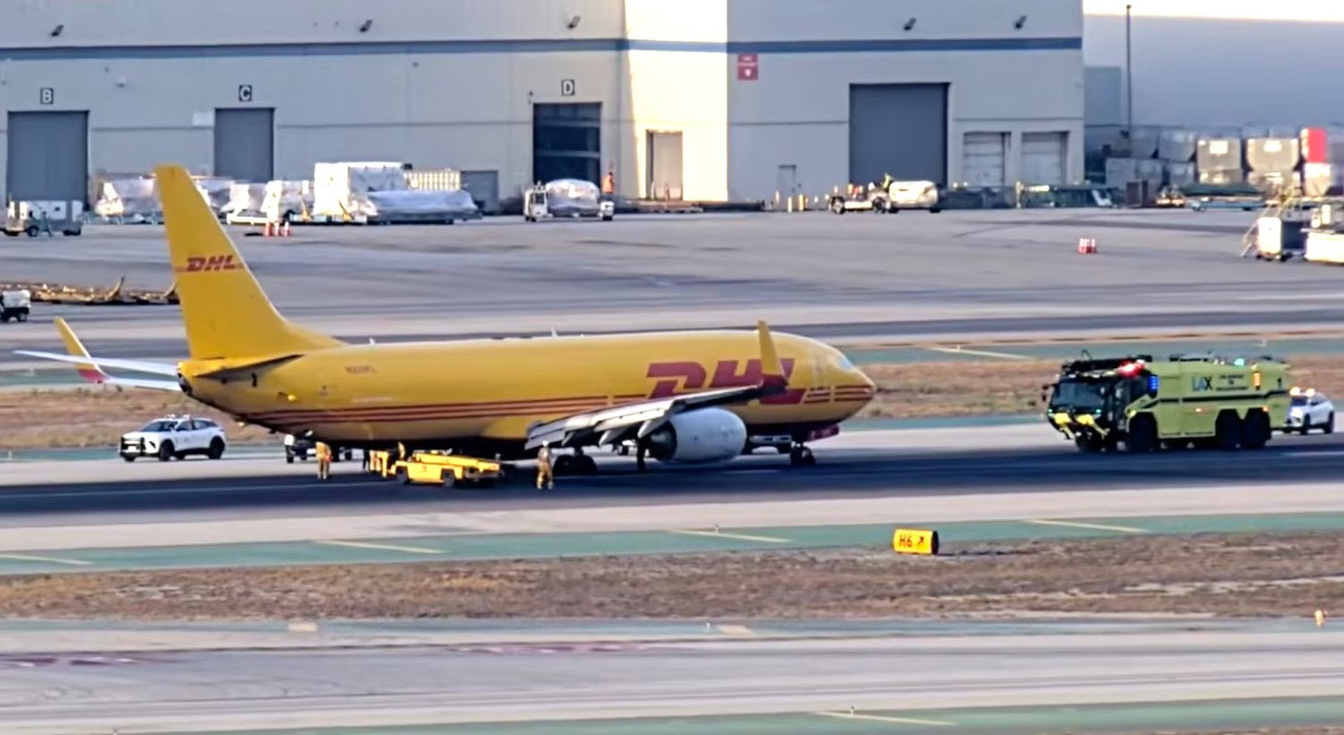Los Angeles, United States: A DHL Boeing 737-800 freighter suffered a brake-system malfunction during landing at Los Angeles International Airport (LAX) on August 26, 2026, causing four tires to blow and a fire to erupt around its main landing gear. The two crew members aboard the aircraft were not injured. The aircraft, a Boeing 737-800BDSF registered as N326FL, was operated by Kalitta Charters II on behalf of DHL as Flight K5-1814 from Phoenix Sky Harbor International Airport to Los Angeles. The freighter landed on Runway 25L at approximately 11:10 p.m. local time. Video footage shows the aircraft touching down before white smoke began emerging from the main landing-gear area. Within seconds, several loud pops and flashes were visible, followed by flames and sparks beneath the aircraft as it continued its landing roll. The aircraft subsequently slowed and stopped on the runway while fire crews moved toward it. Footage showed flames concentrated around the landing-gear and tire area as emergency responders began extinguishing the fire. During the incident, the flight crew communicated with air traffic control about the braking problem. In the recorded radio exchange, one of the pilots said, “I don’t know if we blew a tire, but it feels like the brakes locked up.” The crew also advised the tower that the anti-skid system was inoperative and that the brakes may have locked up, with the crew concerned that some of the tires could have been damaged. The Federal Aviation Administration said preliminary information indicated that the aircraft’s brakes malfunctioned during landing and that four tires were blown. The agency has launched an investigation into the incident, meaning the precise mechanical cause has not yet been established. The Los Angeles Fire Department responded after receiving a report of an aircraft fire at approximately 11:06 p.m. The department deployed 13 units to the scene. Firefighters initially received information indicating an engine fire, but after reaching the aircraft, they determined that the problem involved the landing gear and brakes. The LAFD said the left main landing gear caught fire and that the flames spread to the tires on that side. Firefighters used water to extinguish the fire, and the aircraft's two occupants were able to leave the aircraft without assistance. No injuries were reported. The final LAFD unit left the scene at approximately 12:44 a.m. “The cause of the mechanical failure remains under investigation by the appropriate federal and company authorities,” the Los Angeles Fire Department said. DHL described the event as an “apparent brake system issue” that resulted in a brake overheat. The company confirmed that everyone aboard was safe and said the aircraft operator was working to move the disabled freighter so that it could undergo further inspection and assessment. “There were no injuries, and all crew members are safe,” DHL said. The incident temporarily closed Runway 25L as emergency personnel and maintenance crews dealt with the disabled aircraft. Air traffic control also kept other aircraft clear of the runway while the emergency response was underway. The aircraft remained on the ground at LAX into the following morning while arrangements were made to move it from the runway and assess the damage. N326FL is a Boeing 737-800 that was manufactured in 2001 and later converted from passenger service to the BDSF freighter configuration. The conversion was completed in December 2022. The aircraft was operating in DHL livery under Kalitta Charters II, a U.S. cargo carrier. The available evidence establishes the sequence of events as a normal landing followed by a suspected brake lockup or malfunction, tire failures, a fire involving the main landing gear, the aircraft coming to a stop on Runway 25L, and the subsequent response by LAX emergency crews. However, investigators have not yet identified the specific component or technical failure responsible for the brake malfunction.